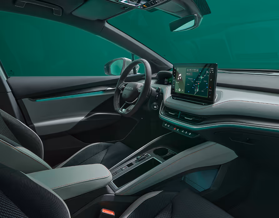 Beifahrer-Perspektive im Innenraum des Škoda Elroq in der Ausstattungslinie “Lodge”. Der Blick fällt auf das Lenkrad, das Digital Cockpit und den zentralen Infotainment-Bildschirm.