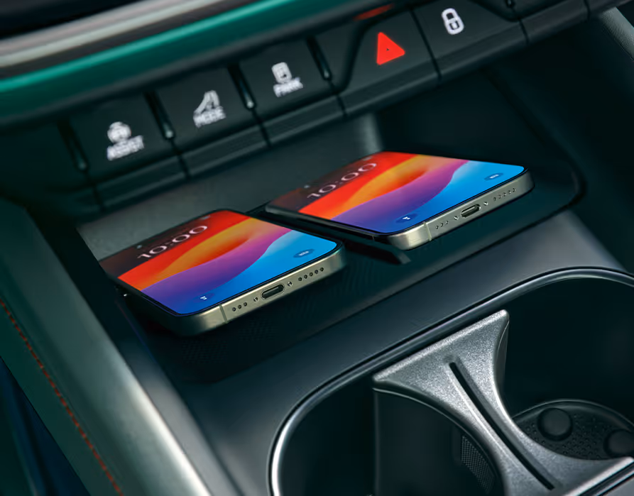 Nahaufnahme der Phone Box in der Mittelkonsole des Škoda Elroq. Zwei Smartphones liegen nebeneinander und werden induktiv (kabellos) geladen.