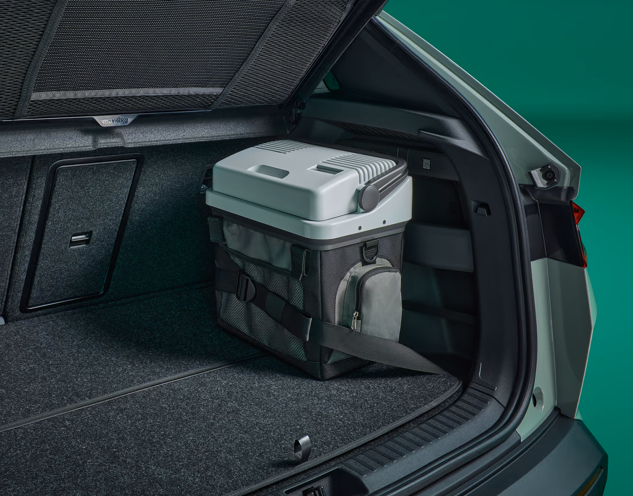 Eine Kühlbox und ein Kofferraumgurt im Laderaum des Škoda Elroq. Der Gurt sichert die Box während der Fahrt.