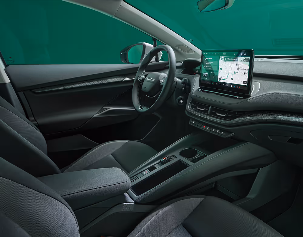 Beifahrer-Perspektive im Innenraum des Škoda Elroq in der Ausstattungslinie “Studio”. Der Blick fällt auf das Lenkrad, das Digital Cockpit und den zentralen Infotainment-Bildschirm.