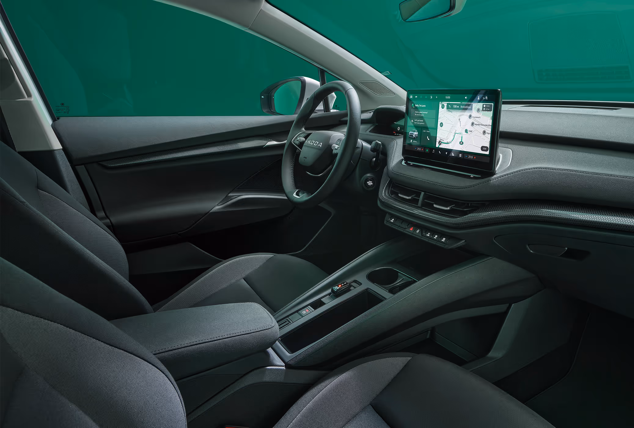 Beifahrer-Perspektive im Innenraum des Škoda Elroq in der Ausstattungslinie “Studio”. Der Blick fällt auf das Lenkrad, das Digital Cockpit und den zentralen Infotainment-Bildschirm.