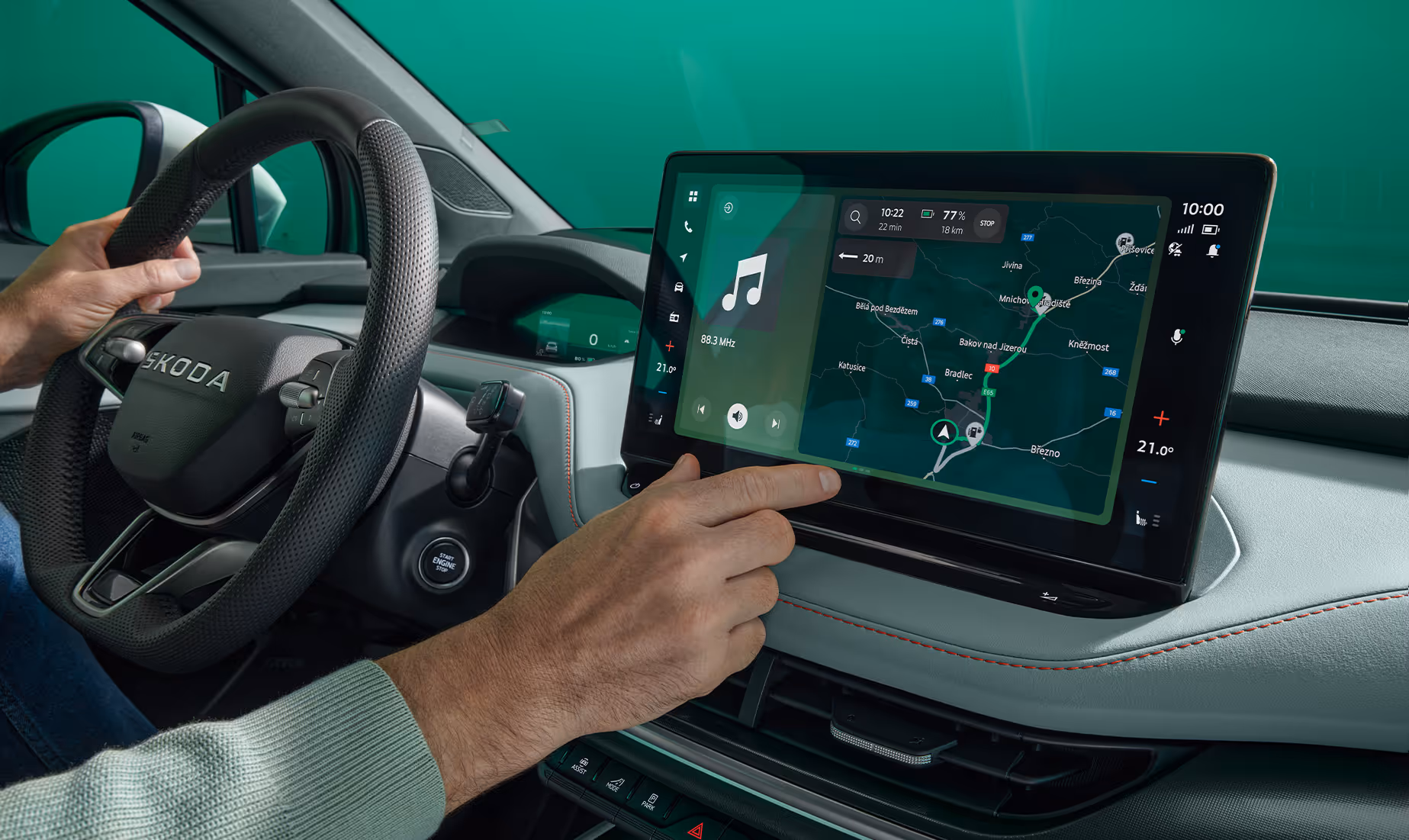 Nahaufnahme einer Hand, die den großen Touchscreen des Infotainmentsystems im Škoda Elroq bedient. Auf dem Display ist die Navigationskarte zu sehen.