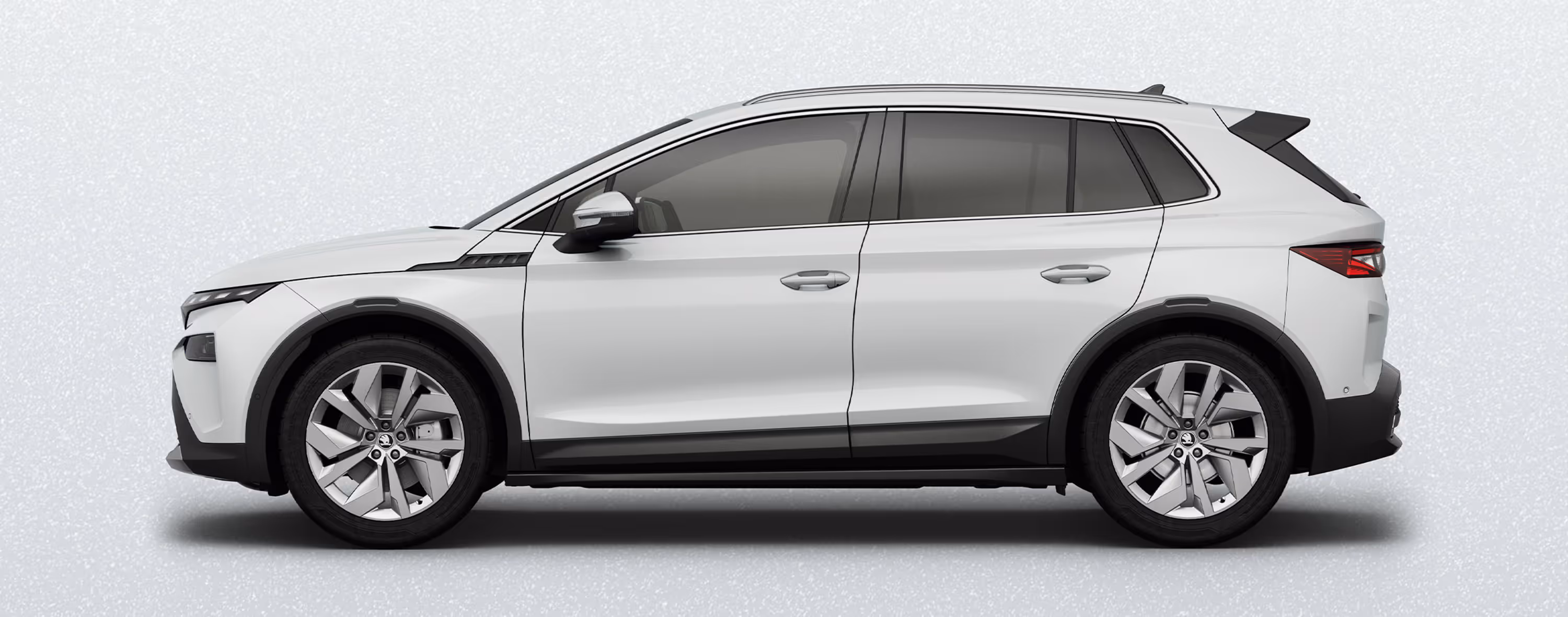 Seitenansicht eines Škoda Elroq in der Farbe Moon-Weiß Perleffekt mit 20 Zoll Leichtmetallfelgen “Vega” vor einem einfarbigen Hintergrund im Farbton der Fahrzeuglackierung.