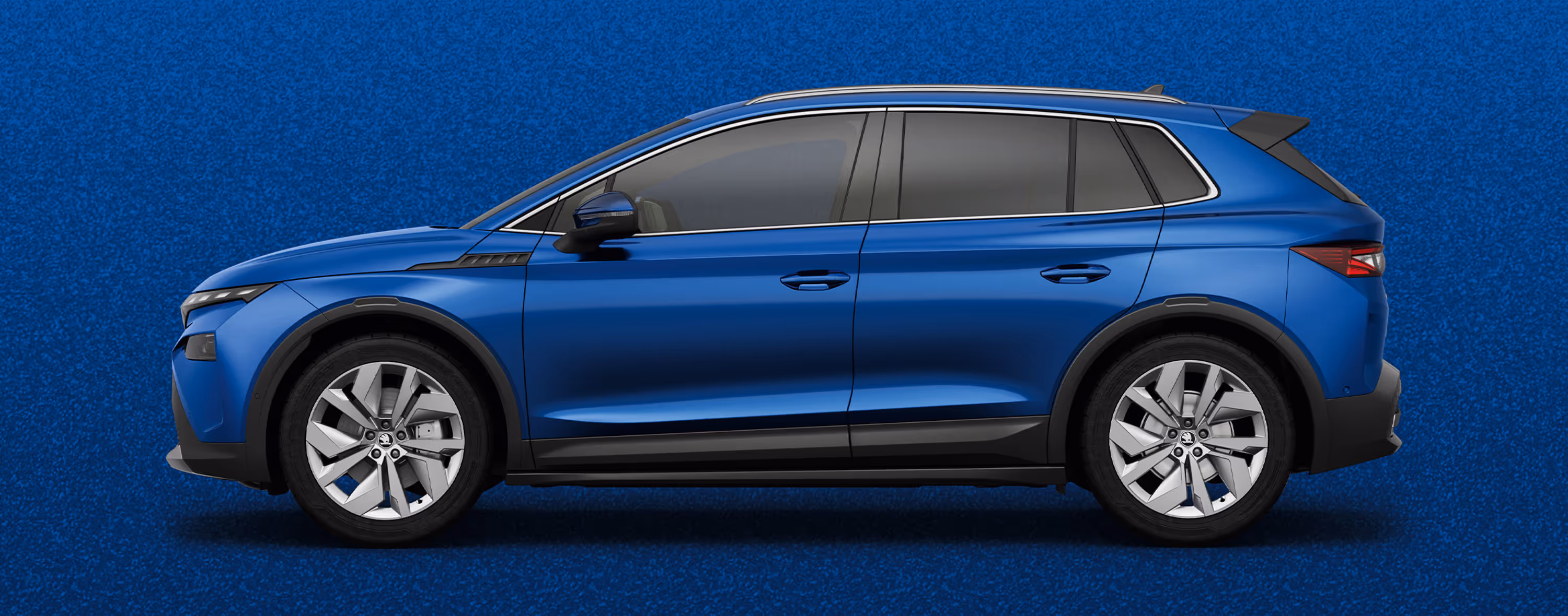 Seitenansicht eines Škoda Elroq in der Farbe Race-Blau Metallic mit 20 Zoll Leichtmetallfelgen “Vega” vor einem einfarbigen Hintergrund im Farbton der Fahrzeuglackierung.