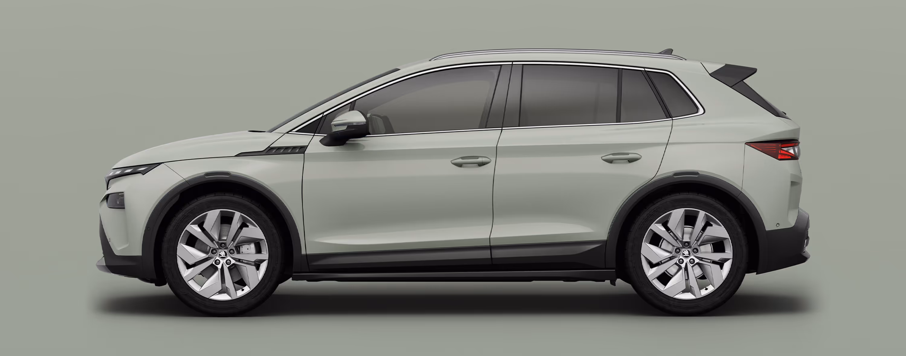 Seitenansicht eines Škoda Elroq in der Farbe Timiano-Grün mit 20 Zoll Leichtmetallfelgen “Vega” vor einem einfarbigen Hintergrund in der Farbe der Fahrzeuglackierung.