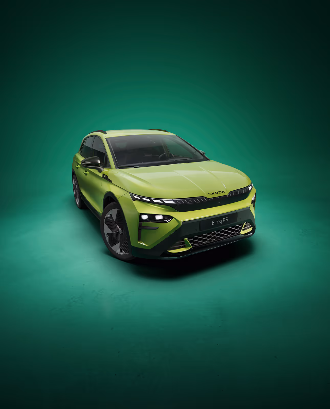 Frontalansicht des Škoda Elroq RS in der Farbe Mamba-Grün vor grünem Studiohintergrund. Das RS-Modell zeigt ein noch aggressiveres Design mit spezifischen Stoßfängern und schwarzen Details.