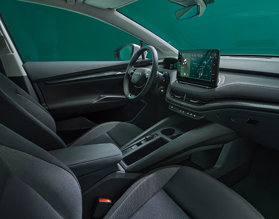 Beifahrer-Perspektive im Innenraum des Škoda Elroq in der Ausstattungslinie “Loft”. Der Blick fällt auf das Lenkrad, das Digital Cockpit und den zentralen Infotainment-Bildschirm.