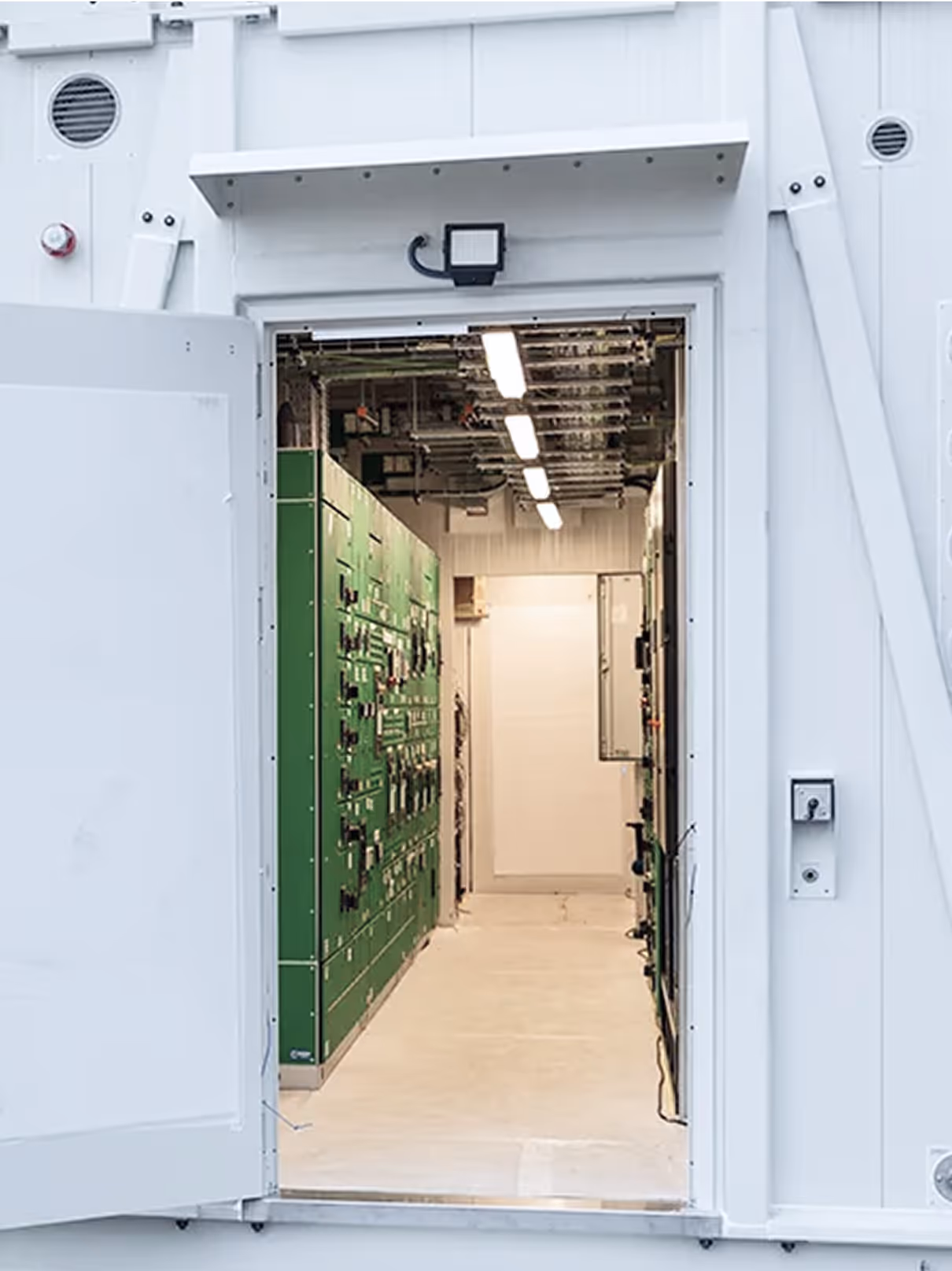 A white doorway with a green door.