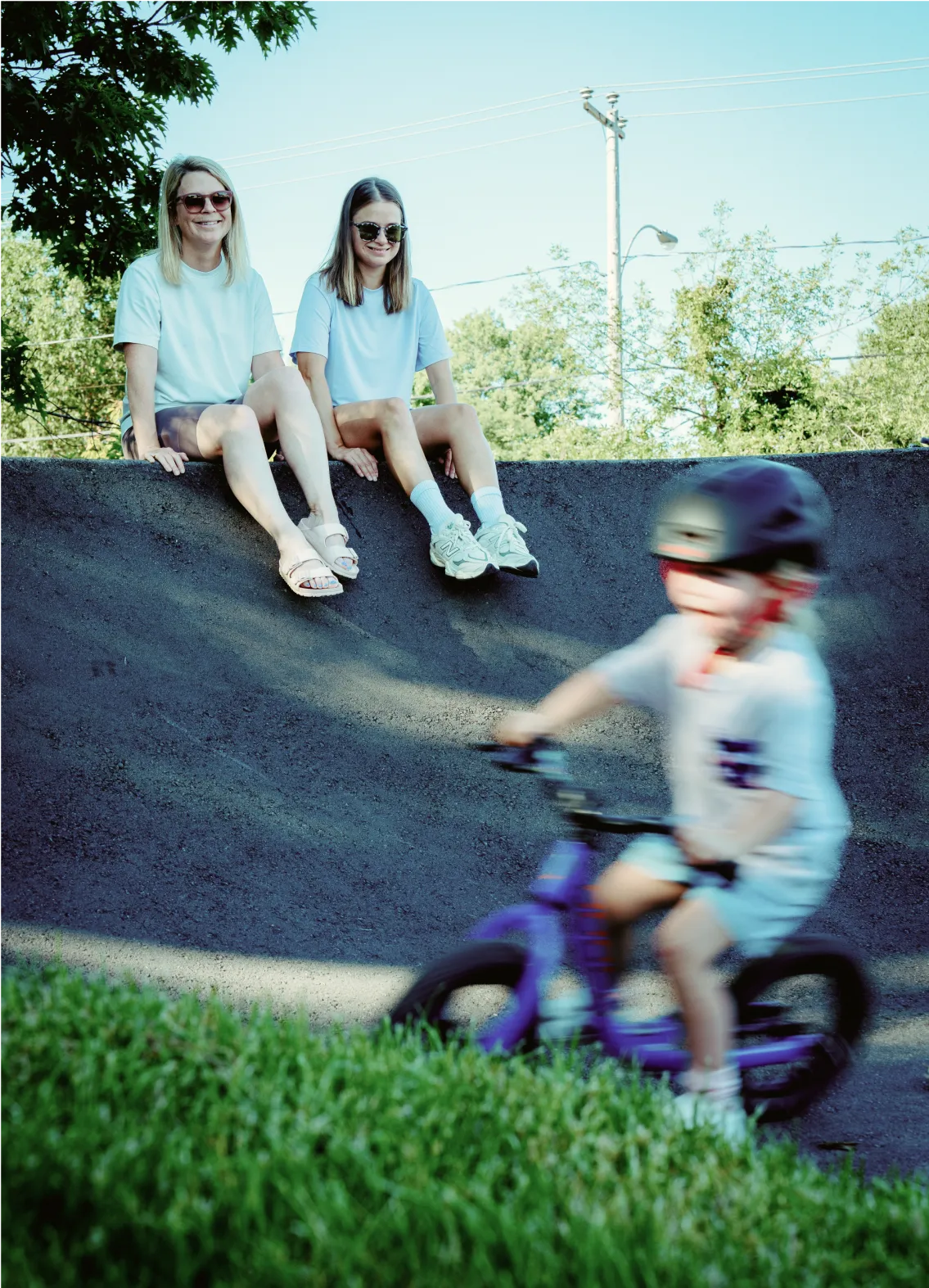 Enfant à vélo dans un skatepark sous supervision des parents