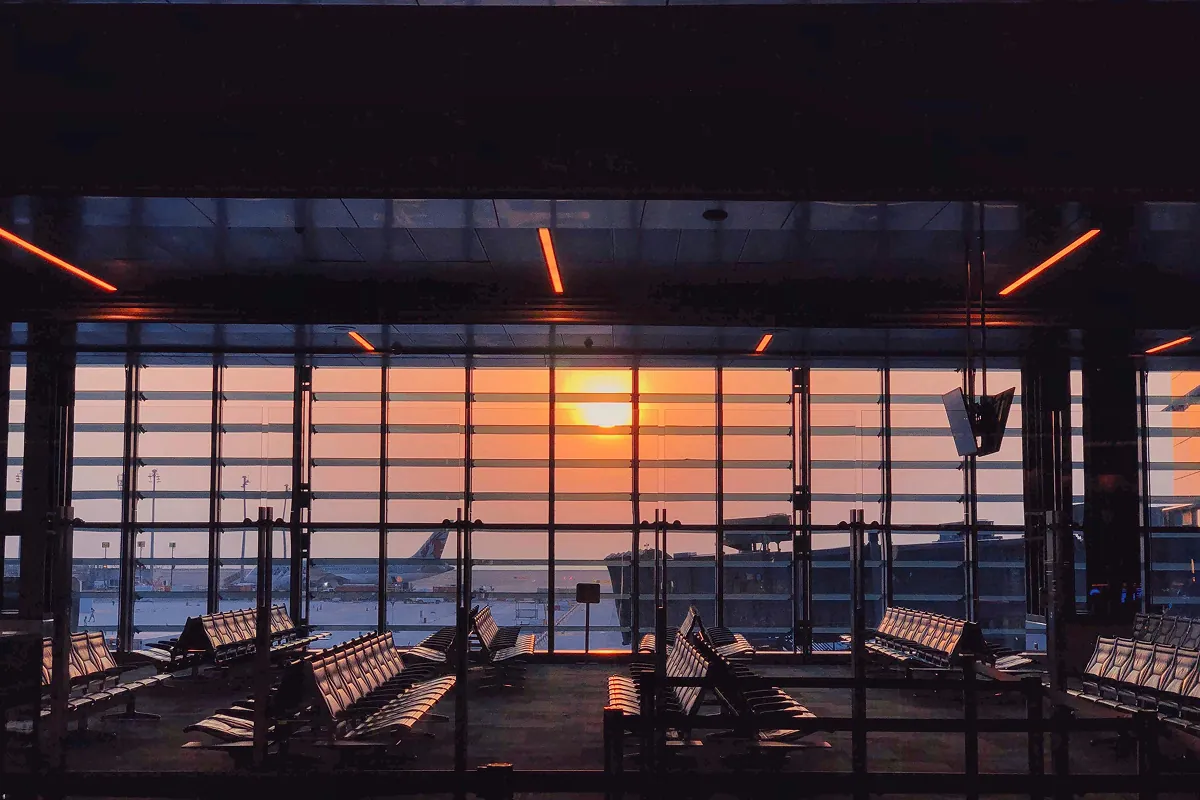 Airport terminal gate area overlooking the runway at sunset