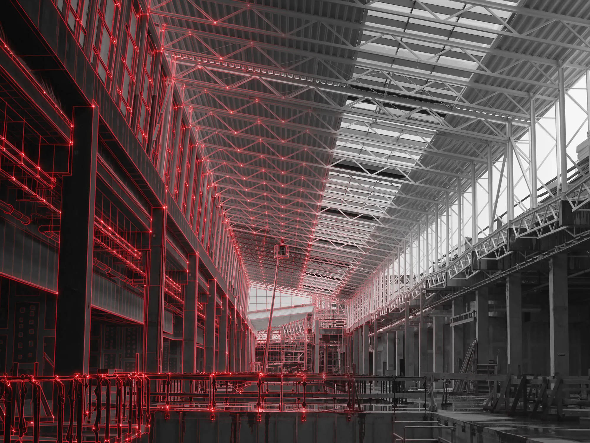 Interior of a large steel-framed industrial building under construction, with a red wireframe overlay