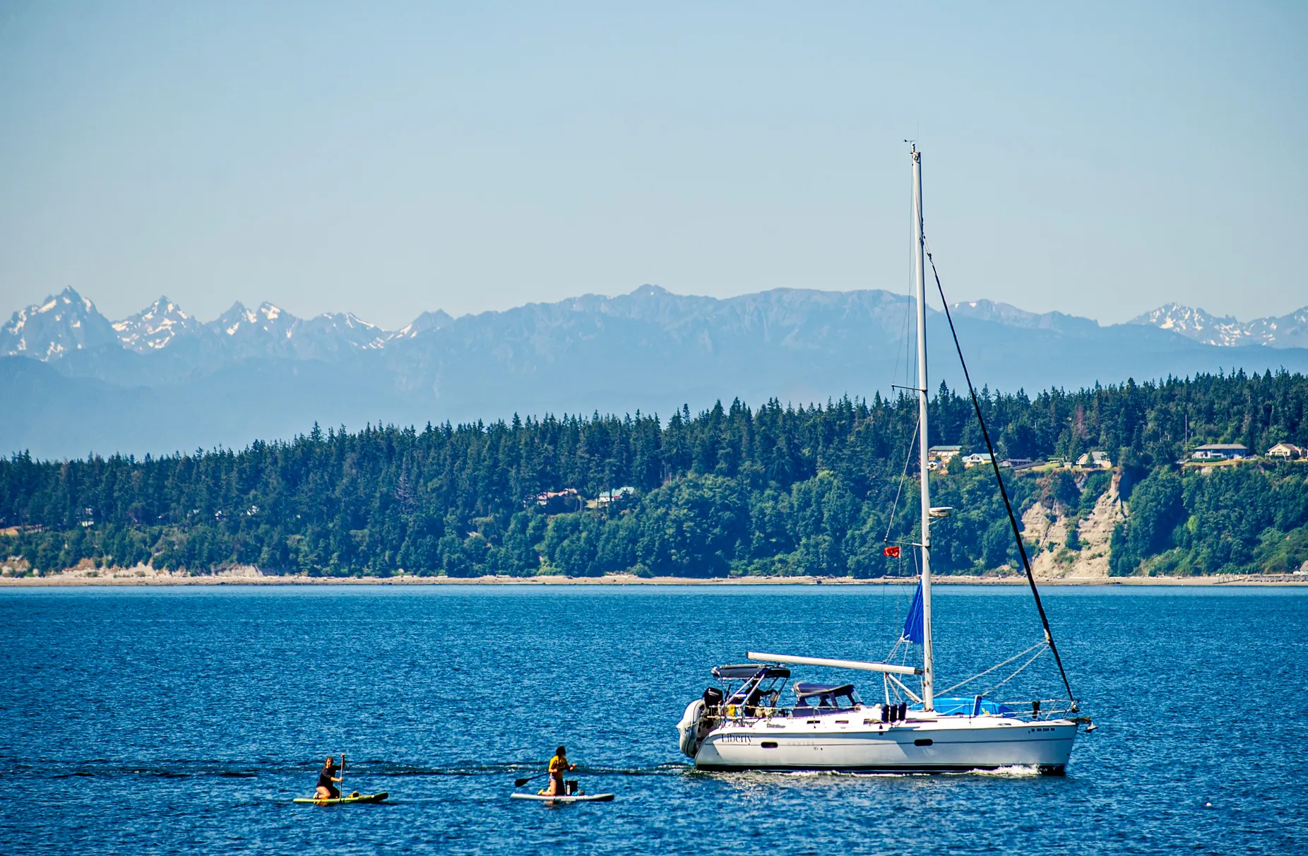 Sailboat and 2 paddle boarders