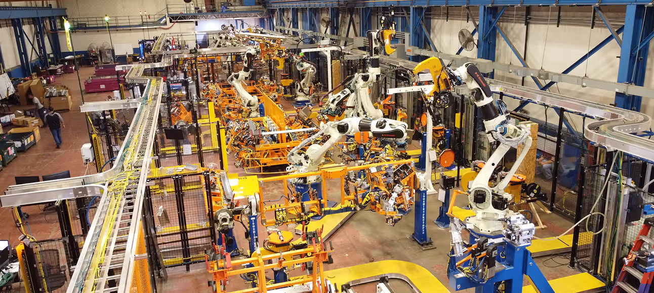 Automated factory assembly line with multiple robotic arms working on manufacturing tasks.