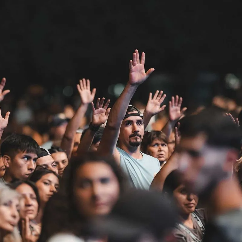 A crowd of people with their hands raised 