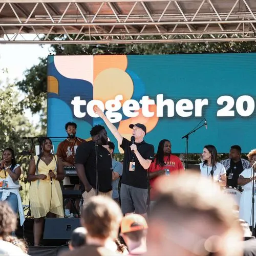 Kevin Palau speaking on stage to a crowd of people
