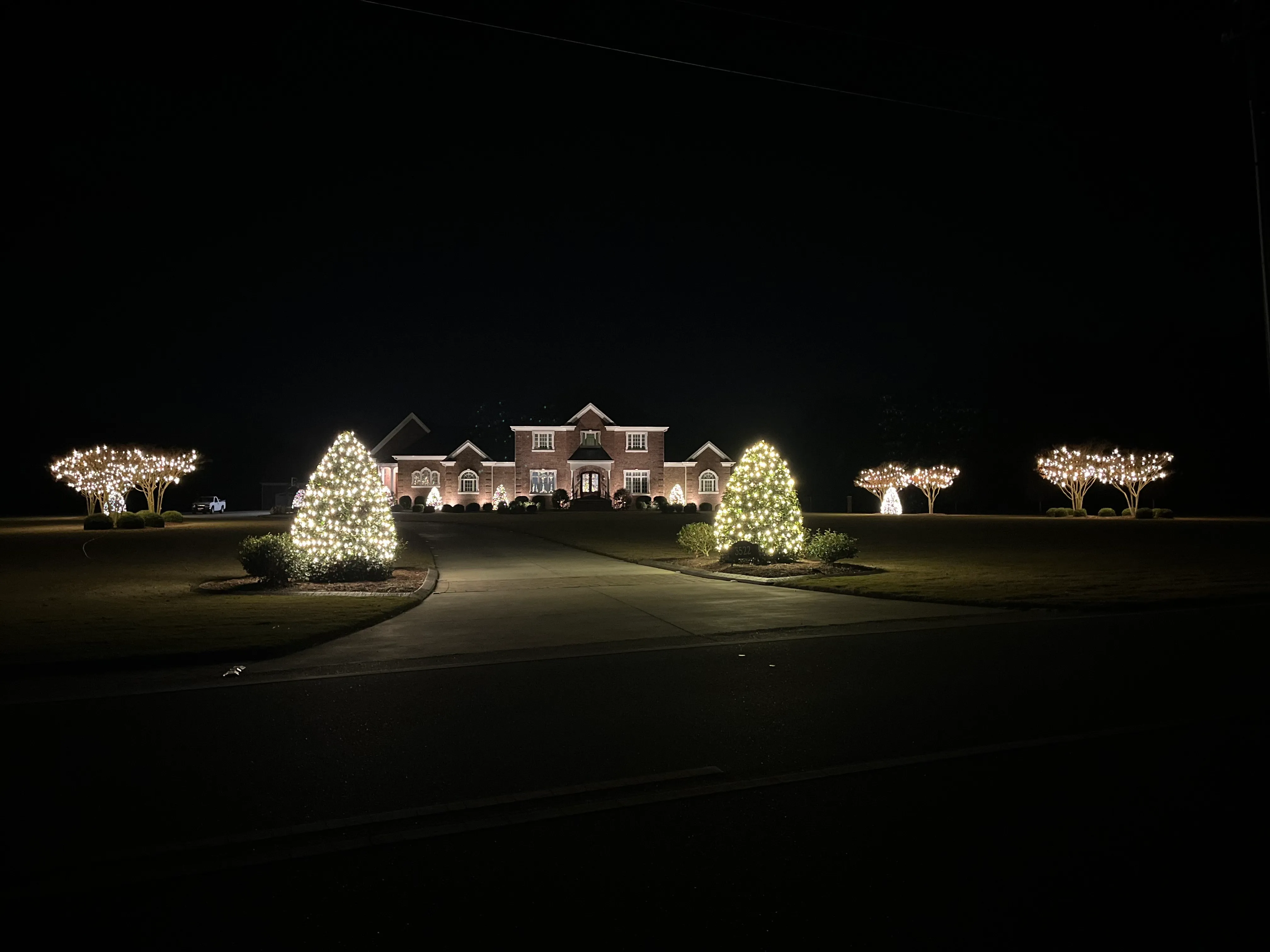 A beautiful, multi-story home with Christmas lights hung on the home and in the yard