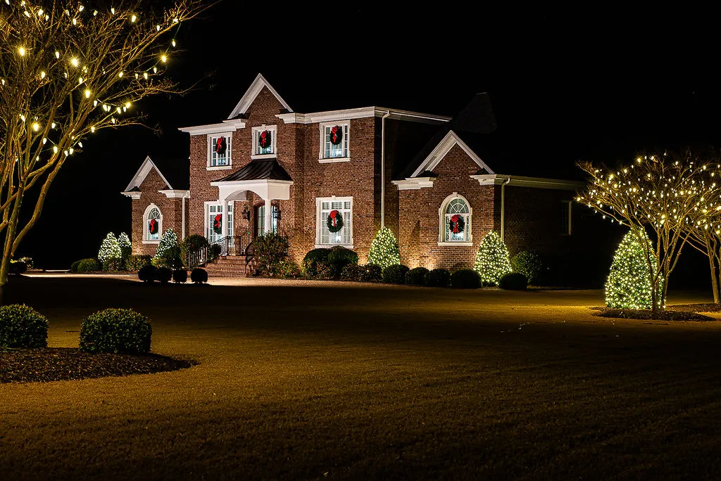 A beautiful, multi-story brick house in Greenville, NC with Christmas Lighting installed by Walston Evans for the holiday season
