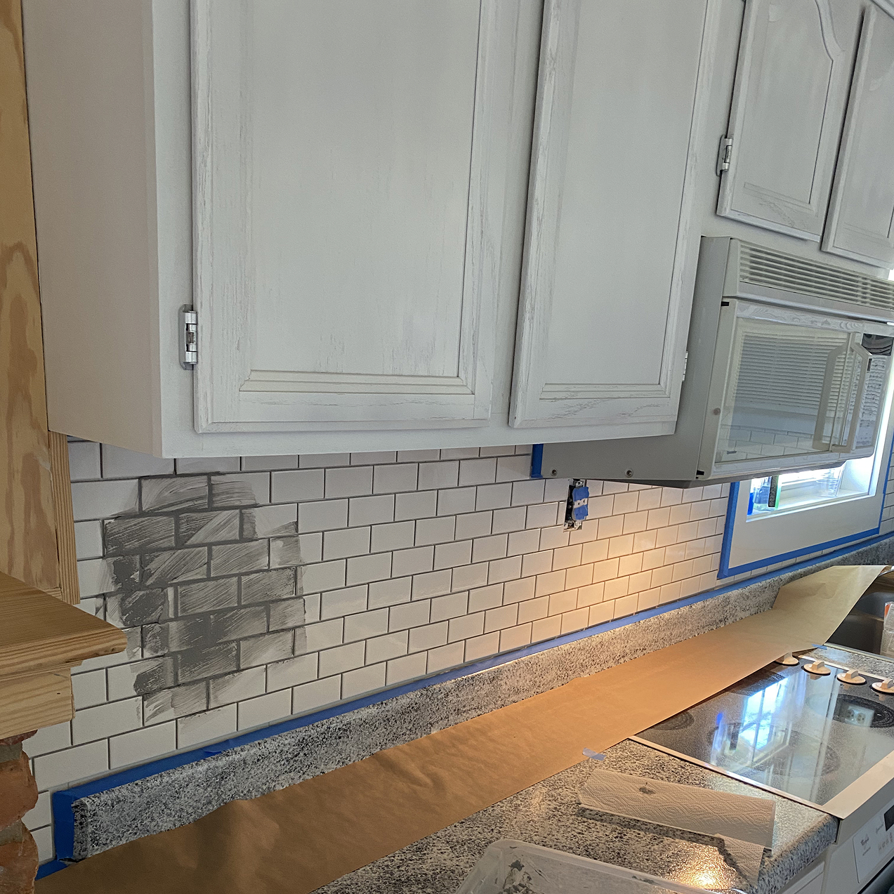 a tile backsplash being added to a kitchen