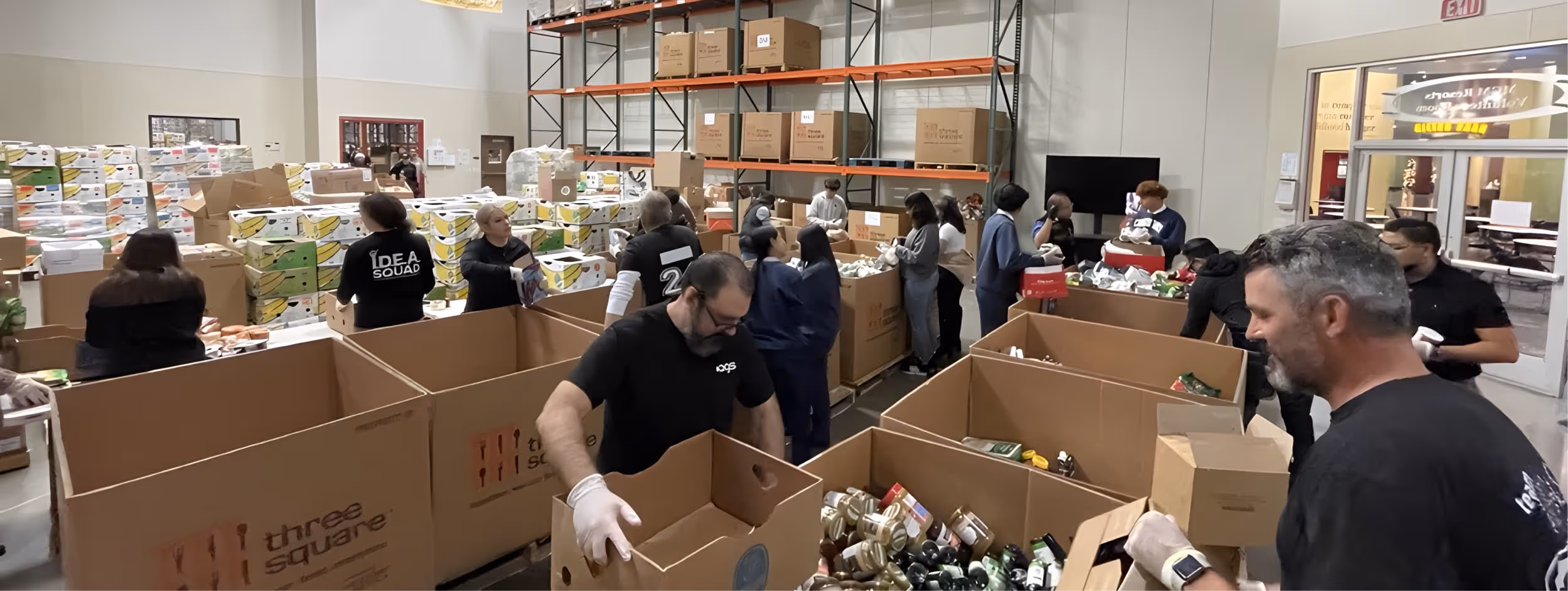 AGS warehouse volunteers sorting and packing donations in large cardboard boxes