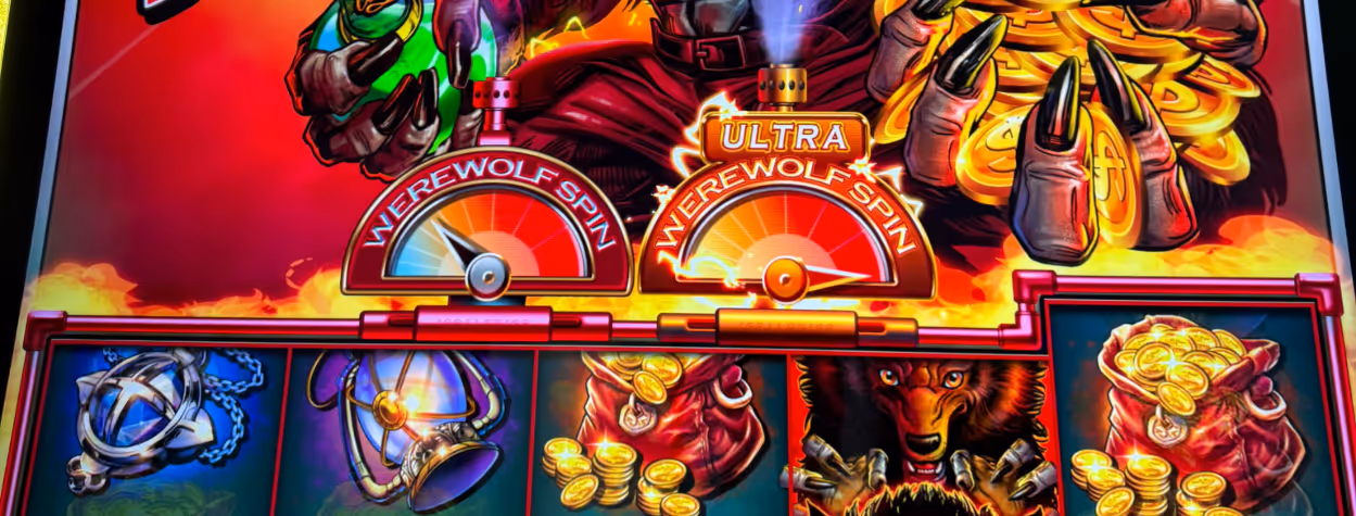 Woman holding a microphone and smiling next to a brightly lit slot machine featuring a werewolf, in a busy casino or gaming convention setting.