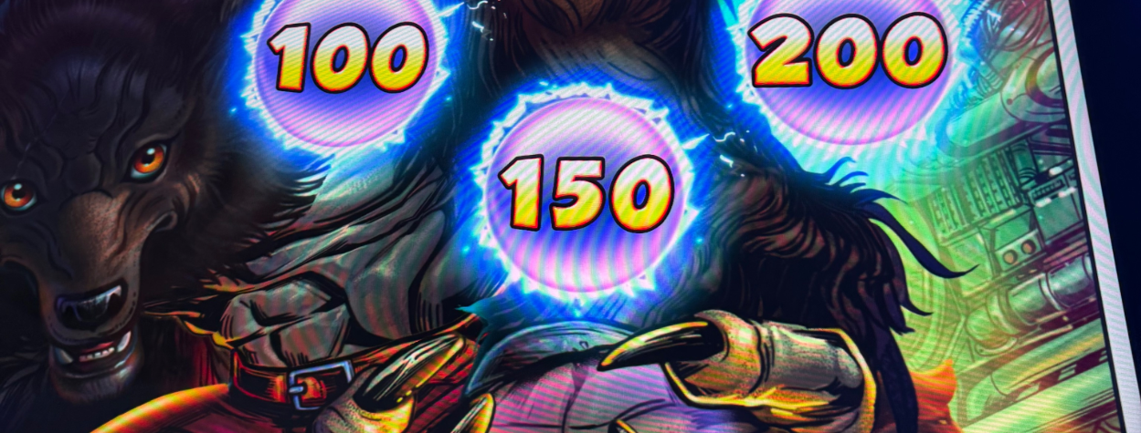 Close-up of an illuminated slot machine's green-lit spin button with colorful game symbols and amounts visible nearby.