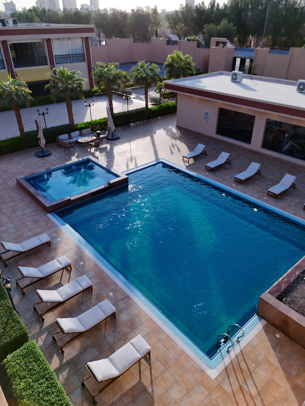 Aerial view of luxury swimming pool and sun loungers at Creative Hospitality Compound in Saudi Arabia