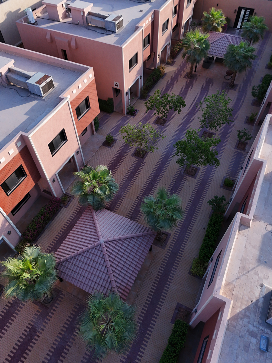 Aerial view of landscaped courtyard with villas and shaded seating at Creative Hospitality Compound in Saudi Arabia