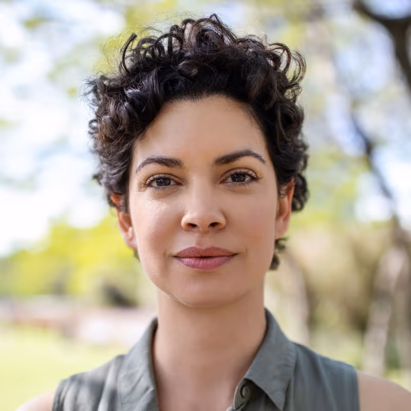 Portrait of a confident young woman in a park. Stock photo. Posed by model.