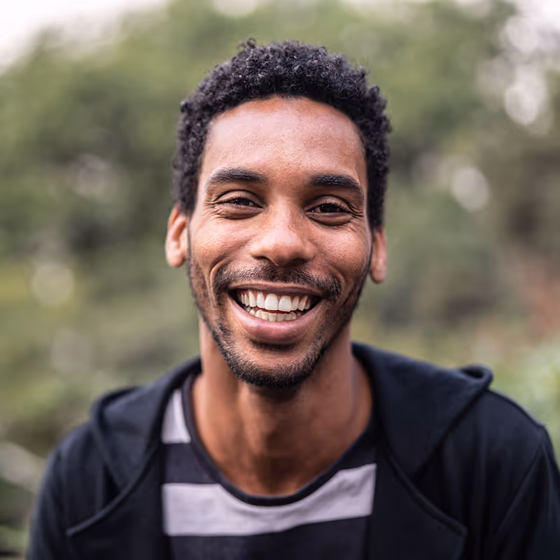 Photo portrait of a Latino-African man smiling at the camera. Stock photo. Posed by model.