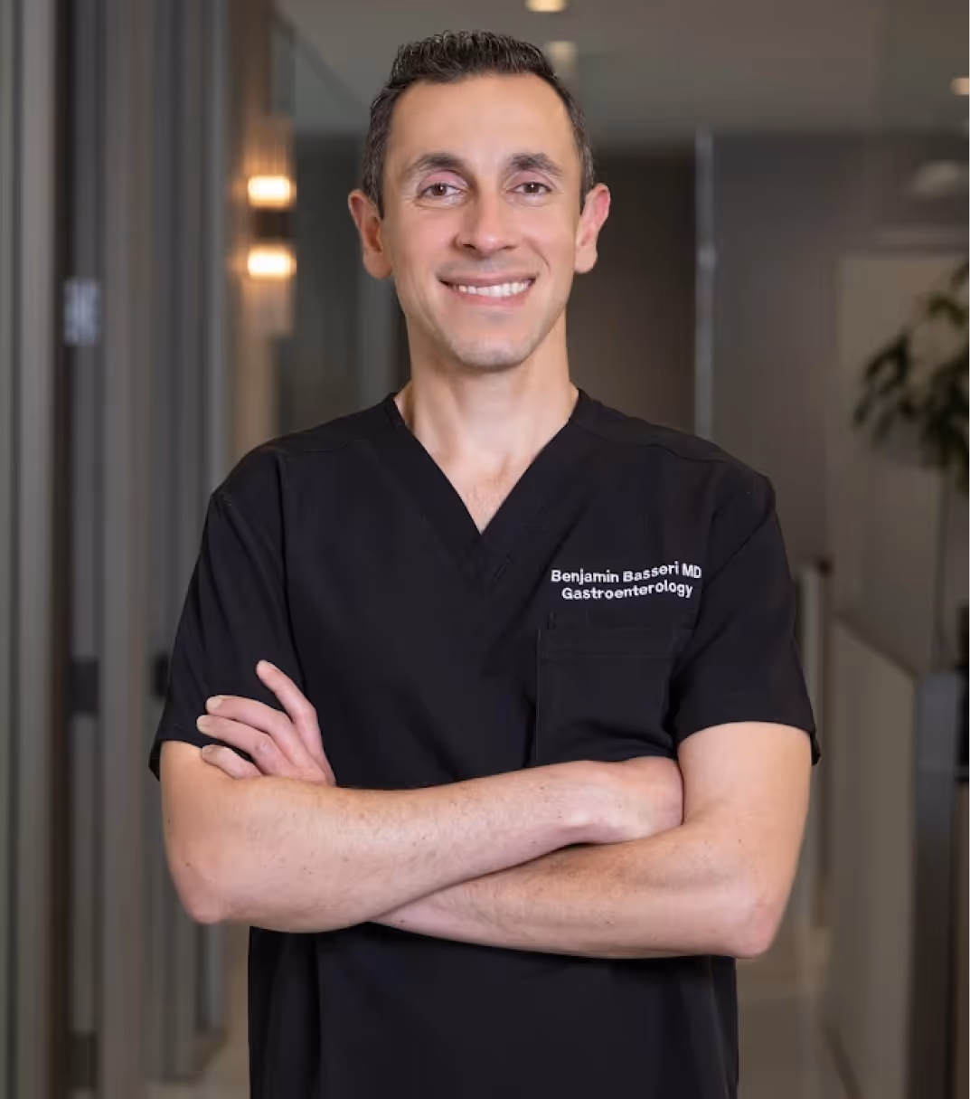 Headshot of Los Angeles's top-rated GI doctor, Benjamin Basseri, smiling at the camera in black scrubs