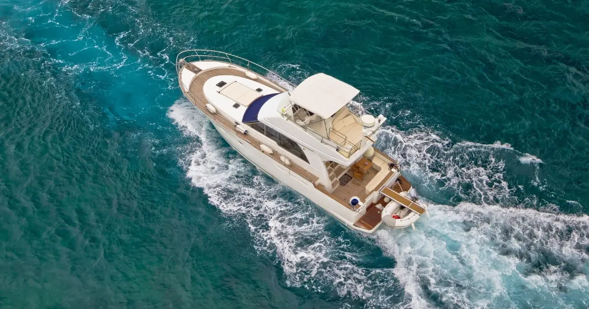 Aerial view of a yacht cruising on clear blue ocean water