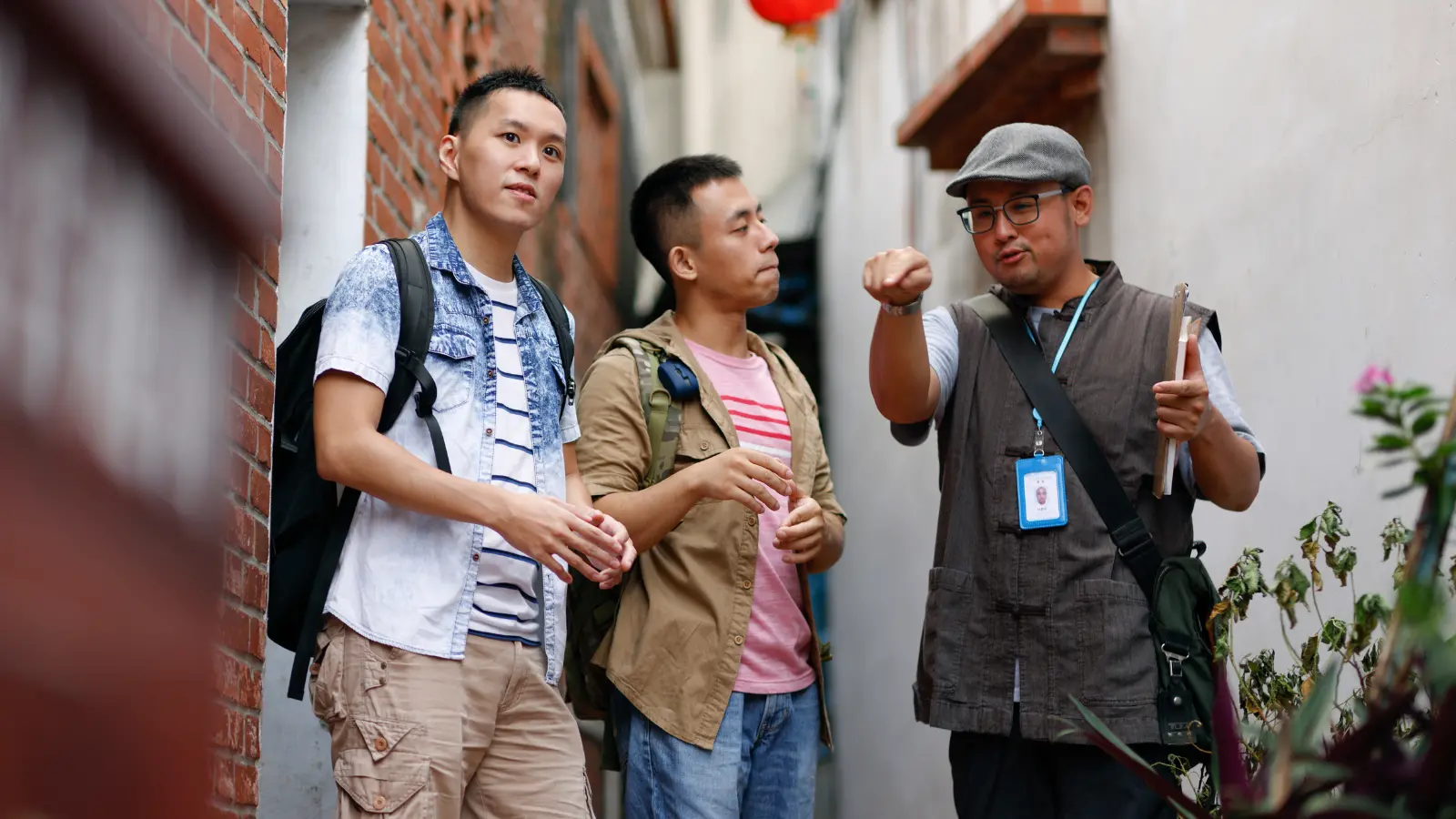 A private tour guide leading two travelers through a narrow city alleyway, pointing out local sights.