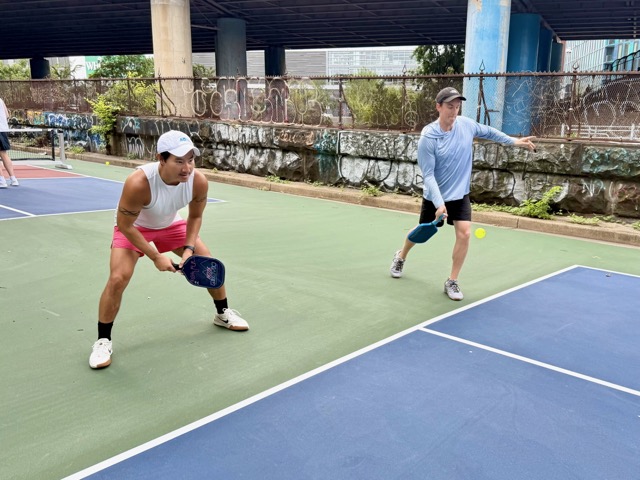 Two players ready at the kitchen line on a Krughoff court