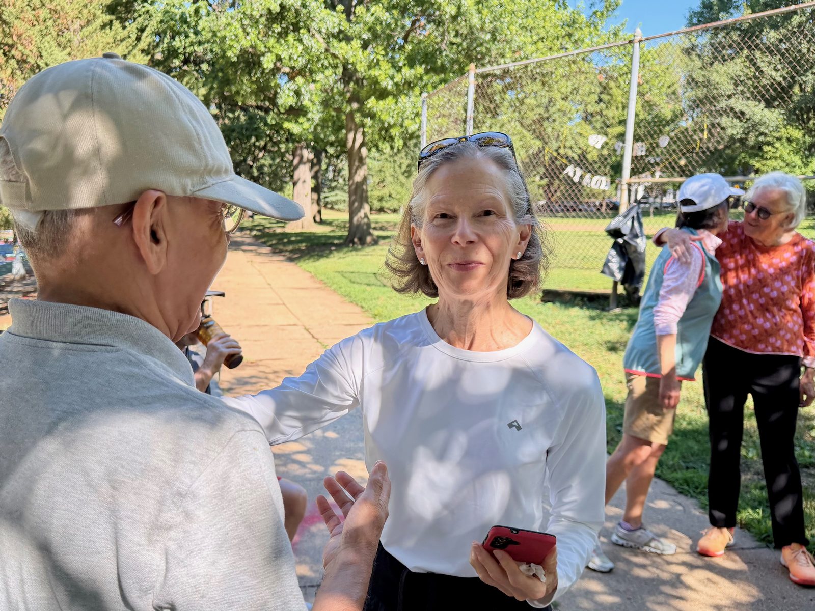 Two longtime players chatting on the path beside the courts
