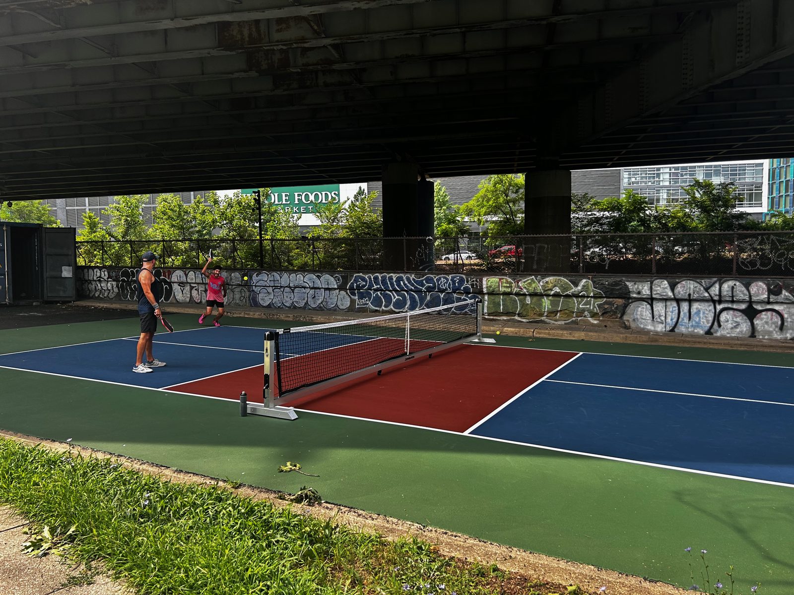 Courts and a graffiti-covered wall beneath the freeway at Bridge Spot