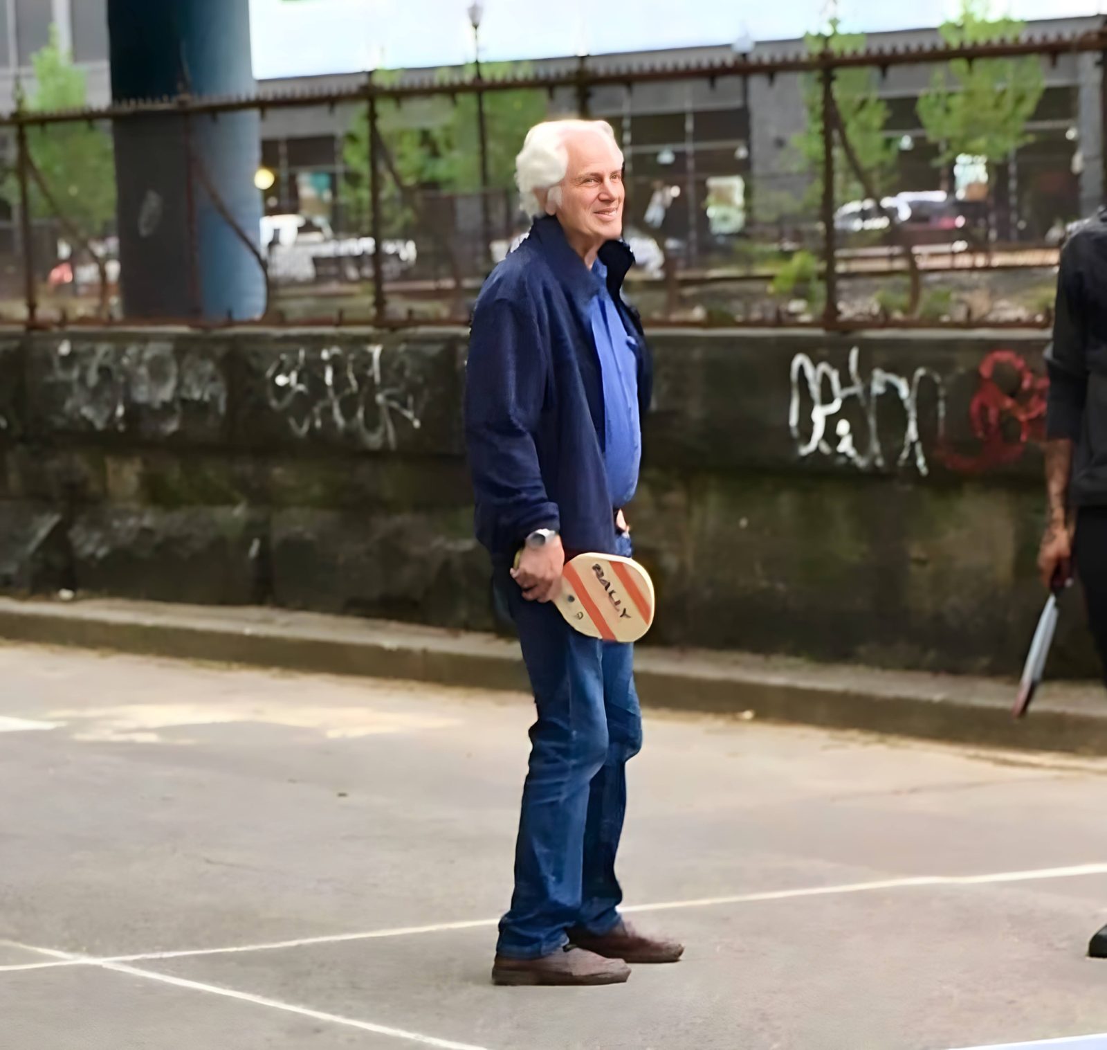 Robert M. Krughoff holding a paddle on the old roadway courts
