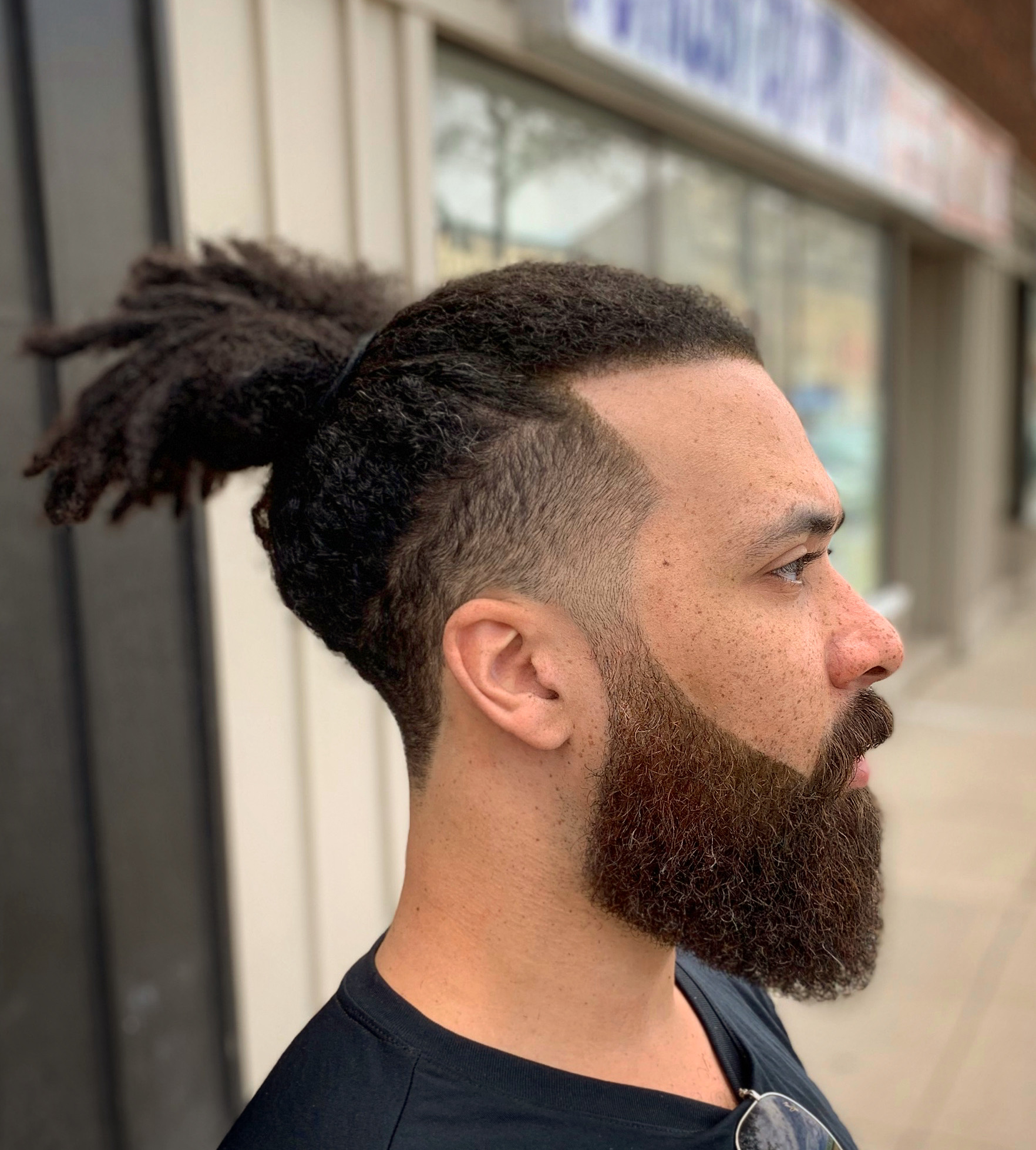 Man with dreadlocked afro hair and a high tapper fade, beard trim line up 
