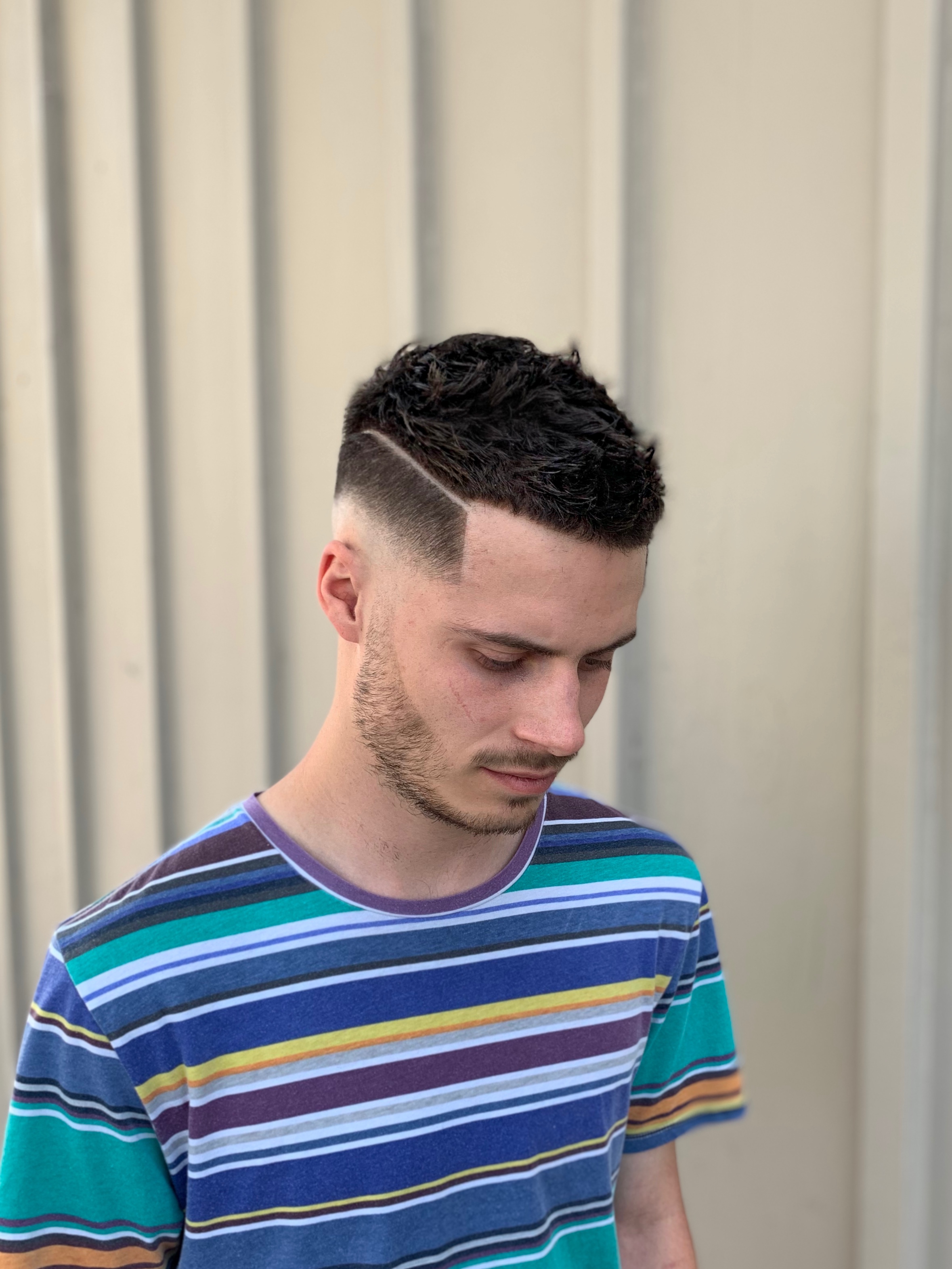 Man with a high-mid skin fade and hard part