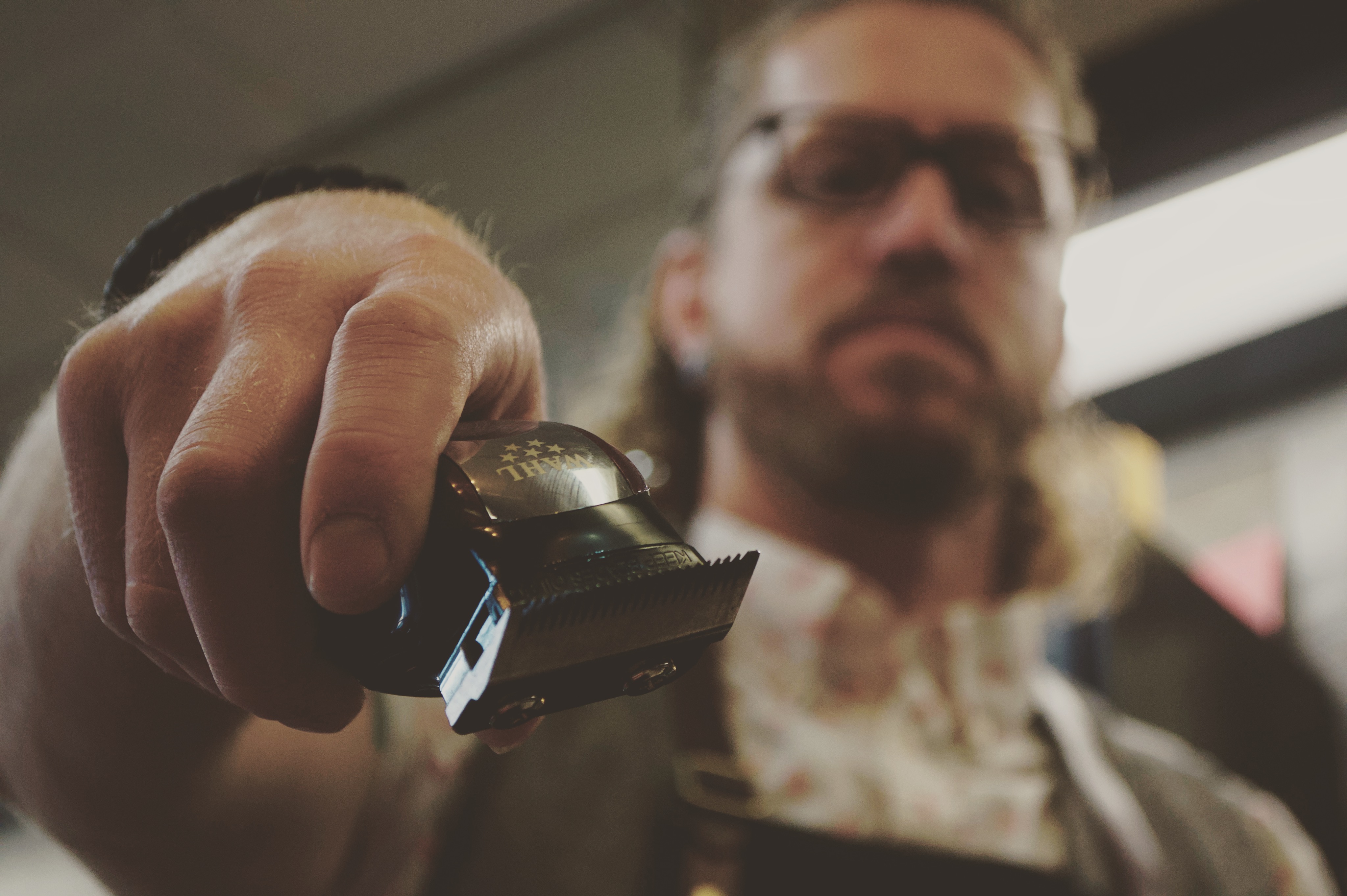 Master Barber Joel is holding his clipper out towards you