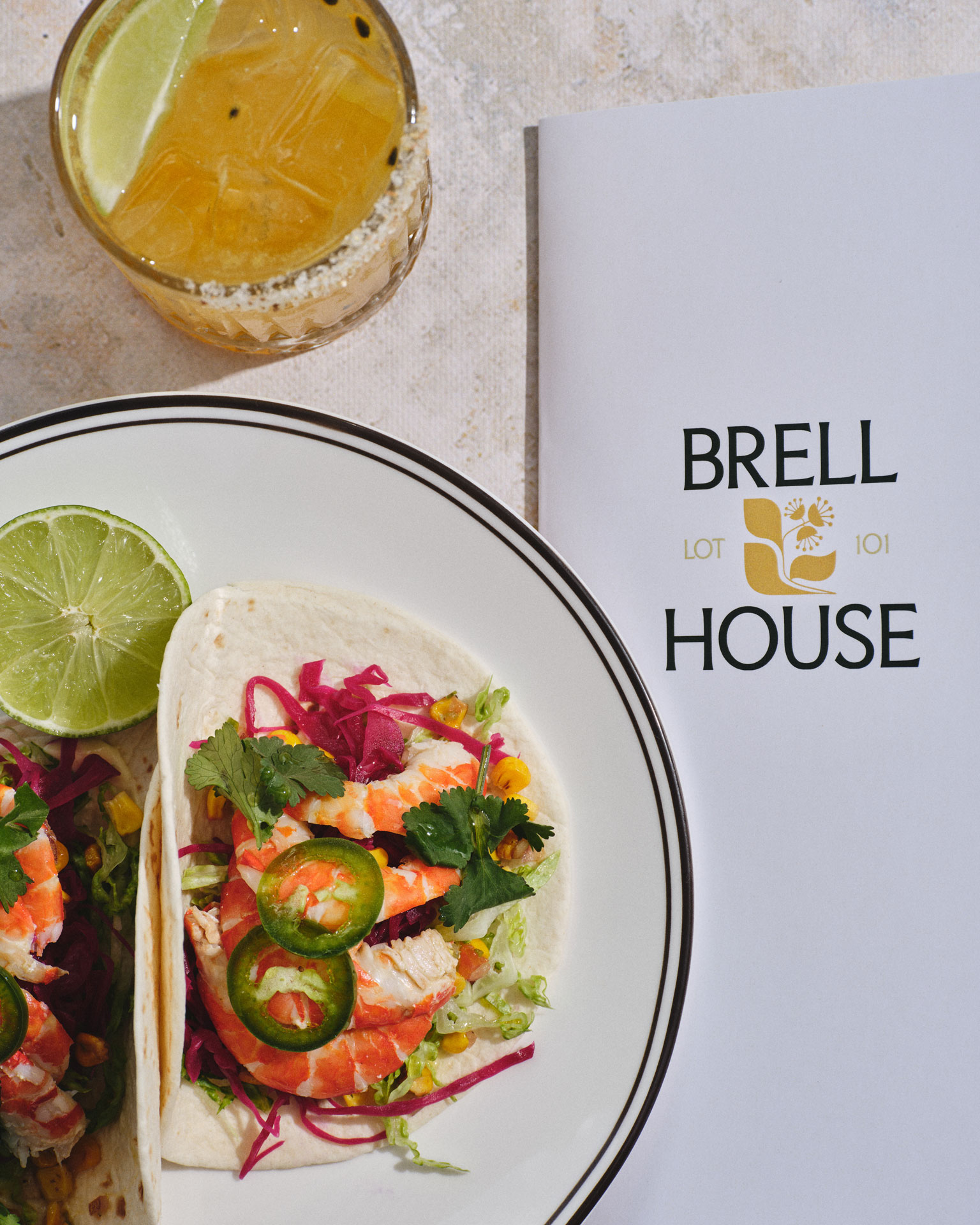 A group of people stands in a room, with several placing hands on one person's shoulders in a supportive gesture. The mood is calm and focused.