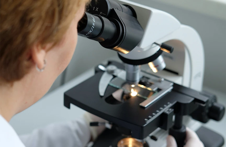 Medical researcher using a microscope