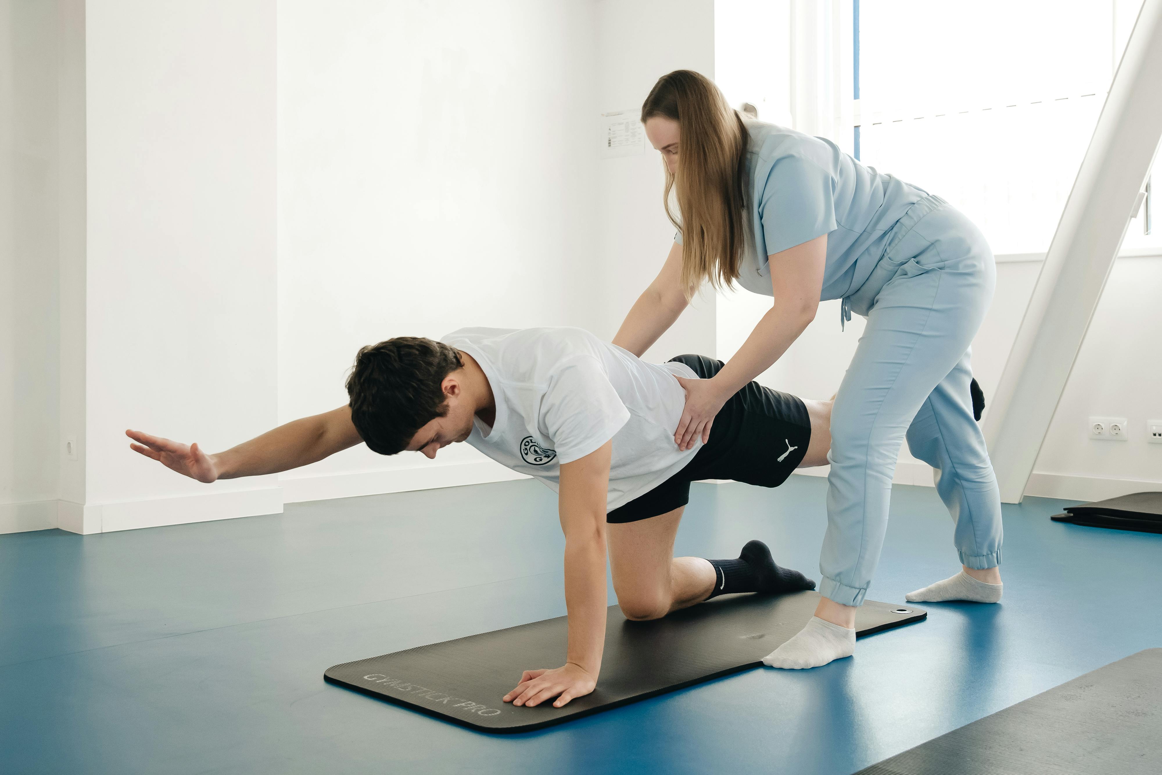 A man and a woman doing push ups on a mat.