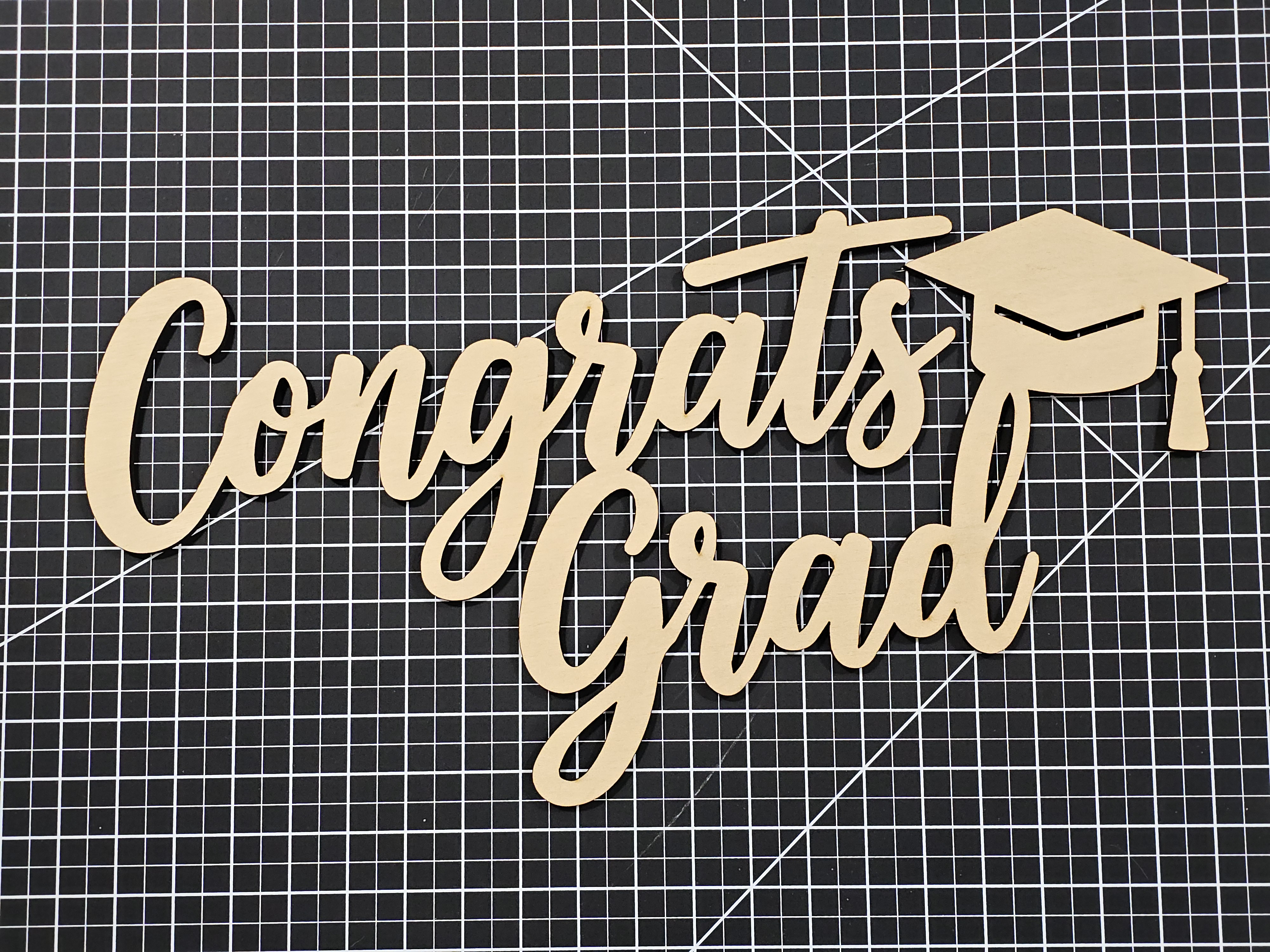 A wooden sign that spells Congrats Grad