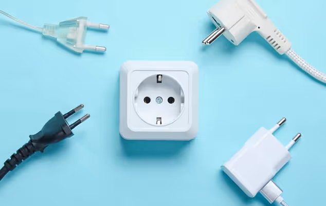 An electrical plug and cable positioned on a solid blue background.