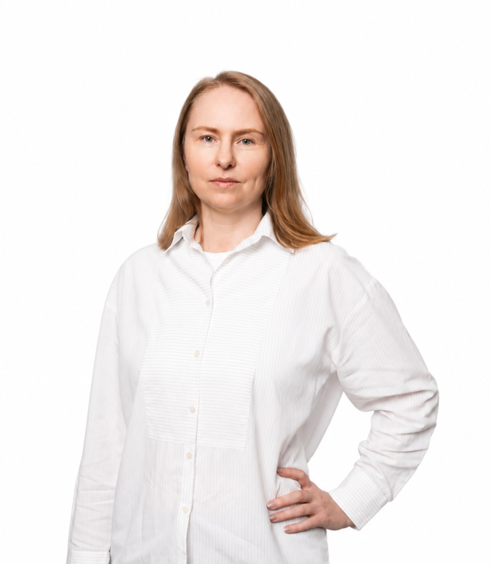 Professional portrait of a woman wearing a sleeveless white blouse and black pants, standing confidently against a clean white background.