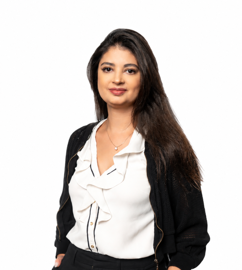 Professional portrait of a woman wearing a sleeveless white blouse and black pants, standing confidently against a clean white background.