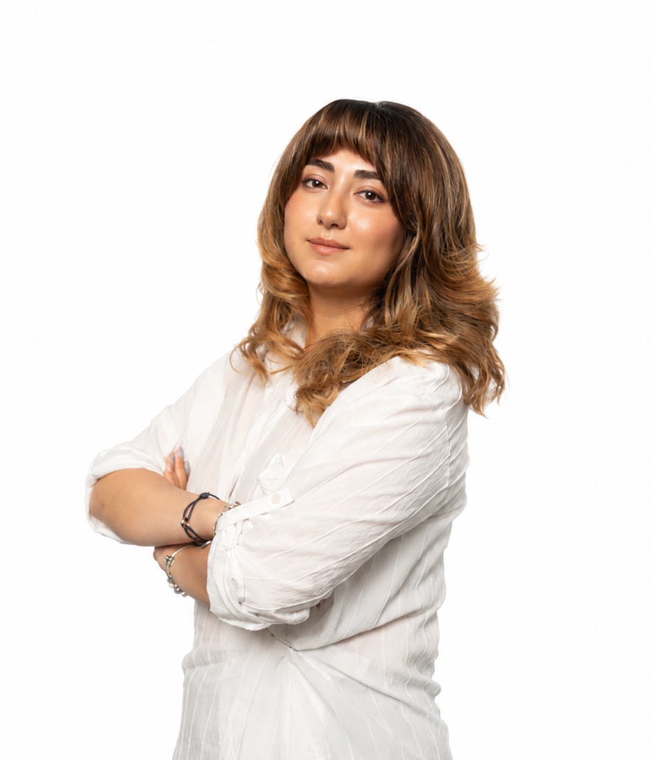 Professional portrait of a woman wearing a sleeveless white blouse and black pants, standing confidently against a clean white background.