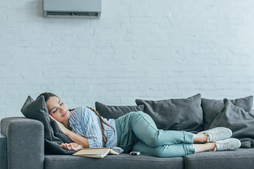 young woman sleeping comfortably under air conditioner