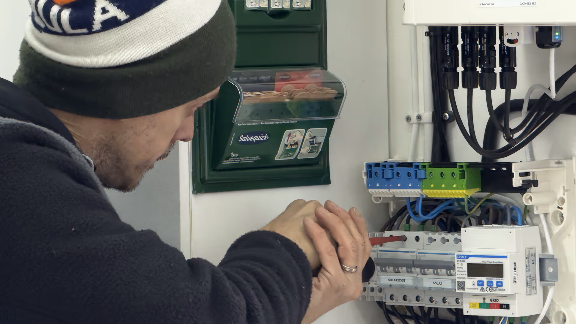 Elektriker skruvar i en elcentral