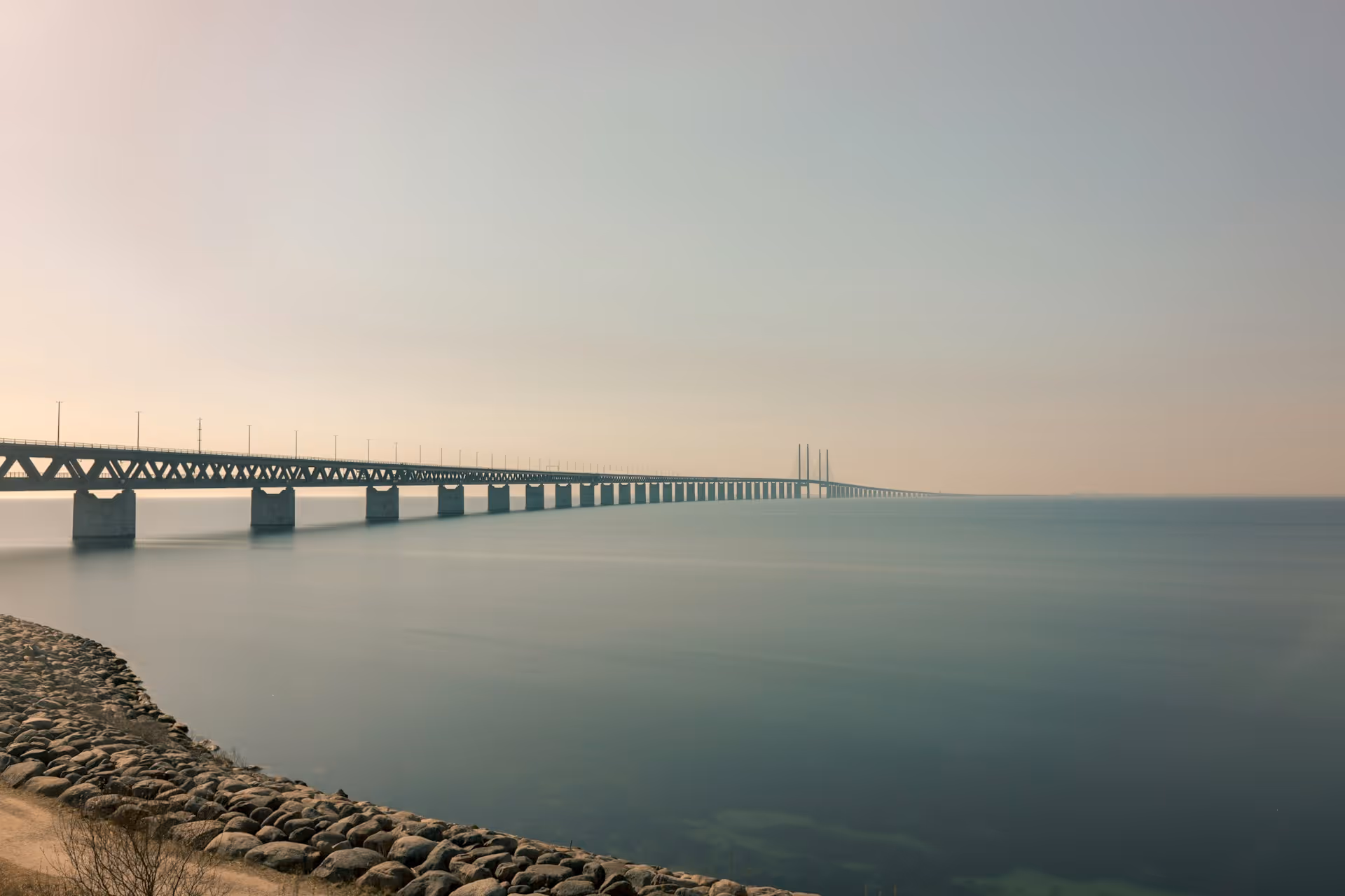 Öresundsbron som sträcker sig över lugnt vatten under en klar himmel.